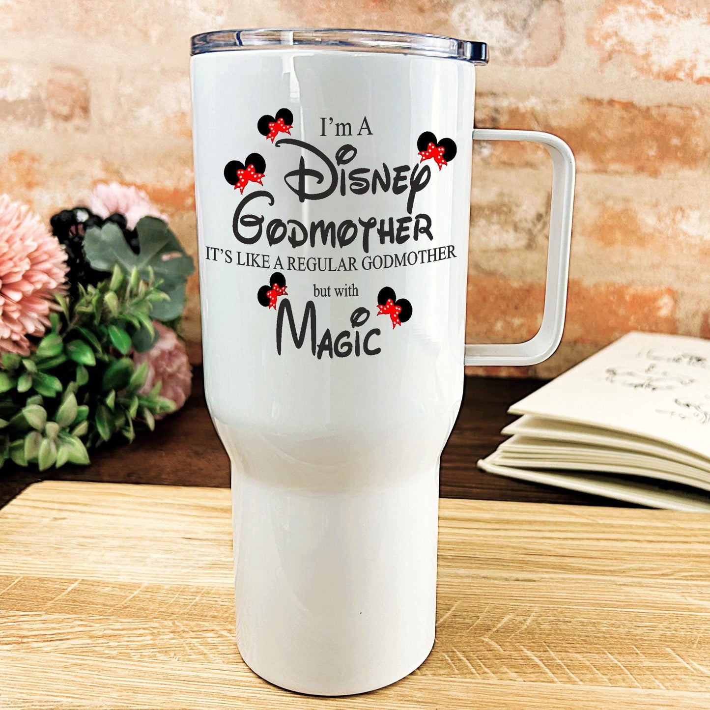 a white travel mug sitting on top of a wooden table