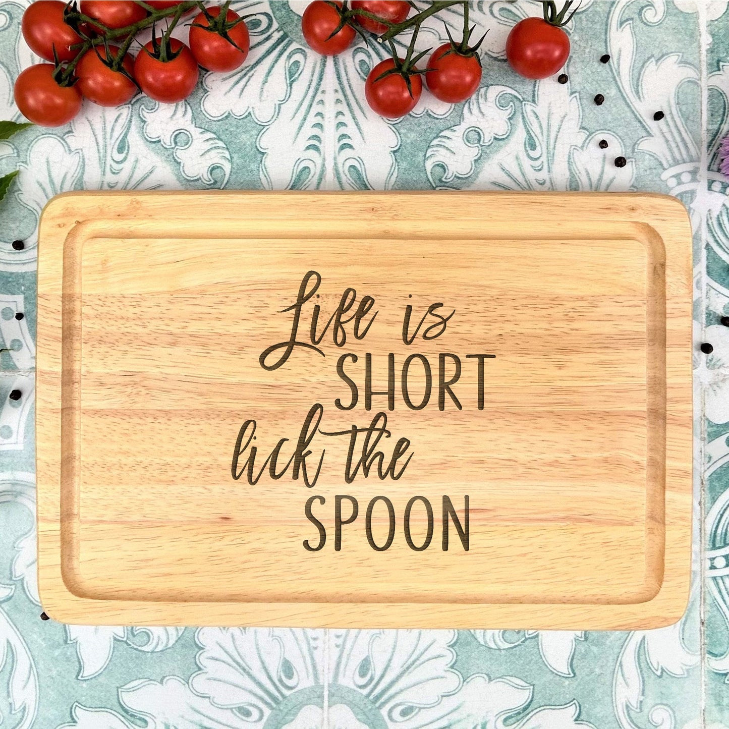 a wooden cutting board that says life is short kick the spoon