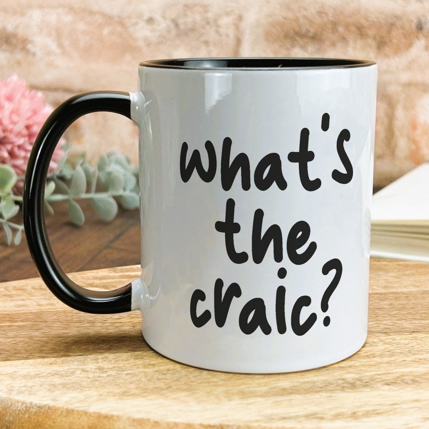 a black and white coffee mug with the words what's the craic