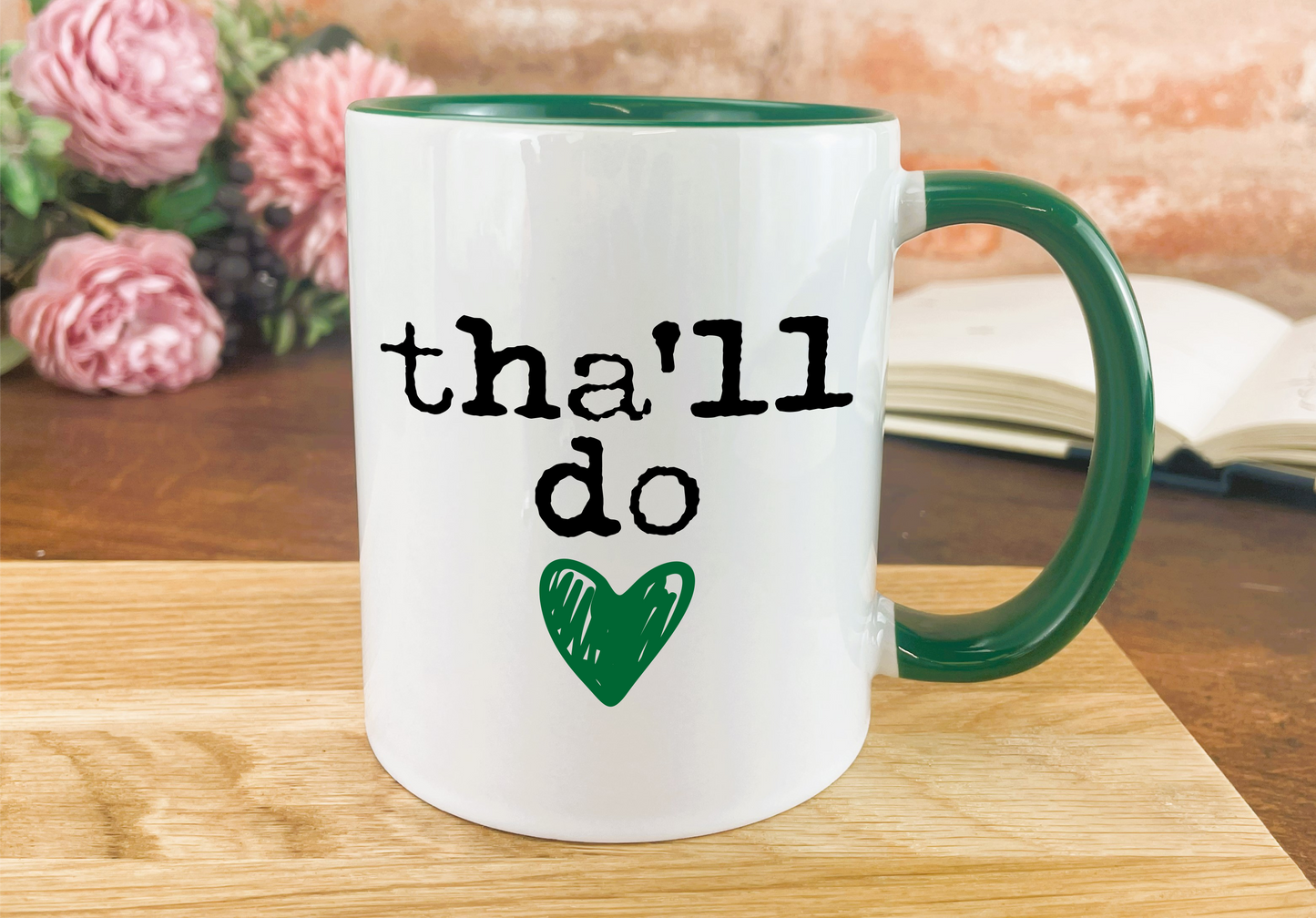 a green and white coffee mug with the words thal do on it