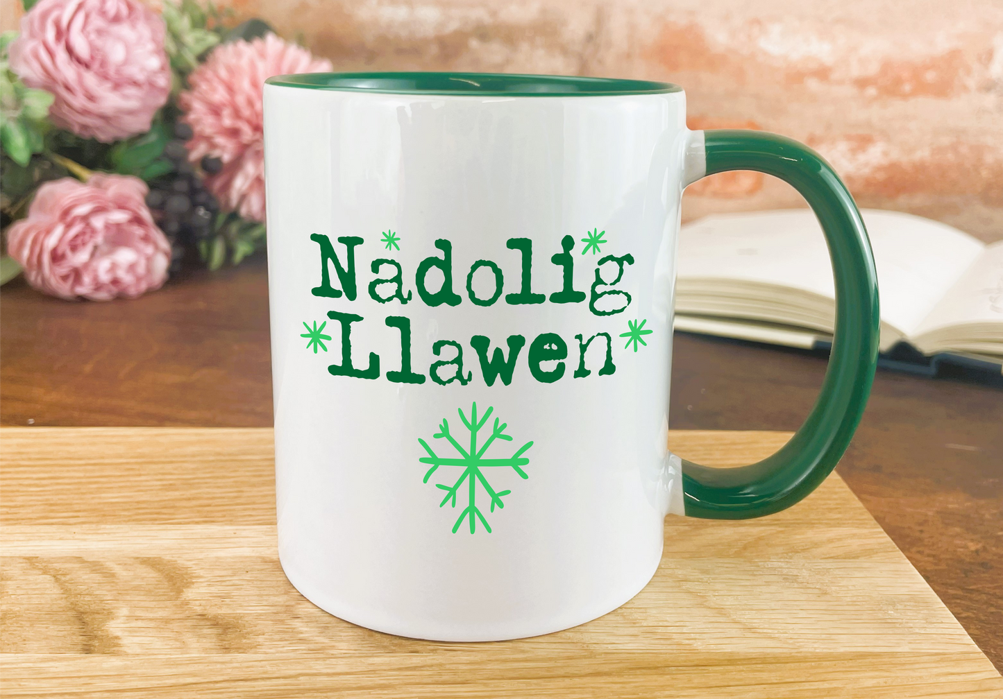 a green and white coffee mug sitting on top of a wooden table