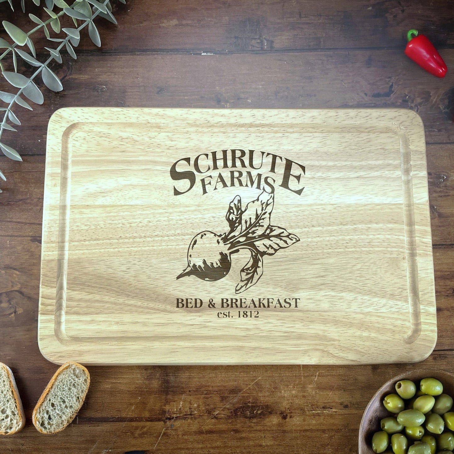 a wooden cutting board with a picture of a bear and a bowl of olives