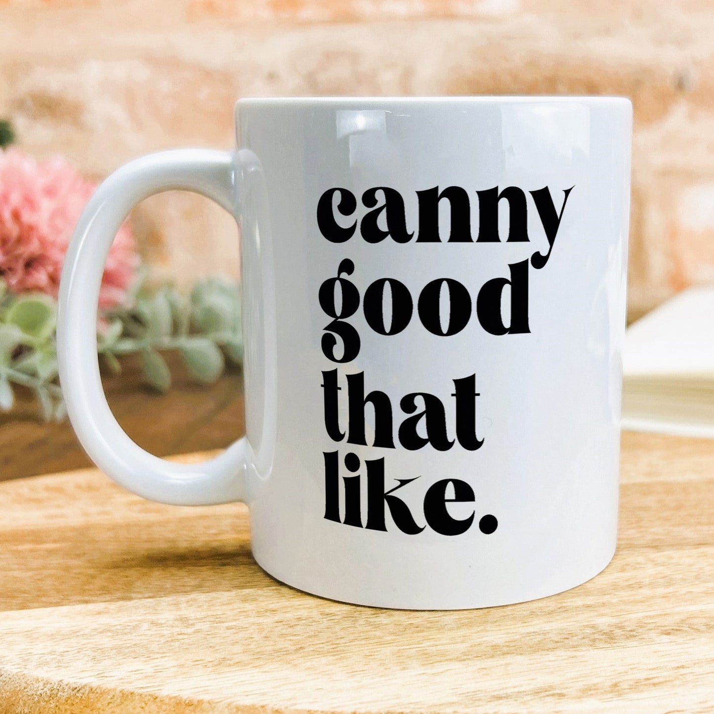 a white coffee mug sitting on top of a wooden table