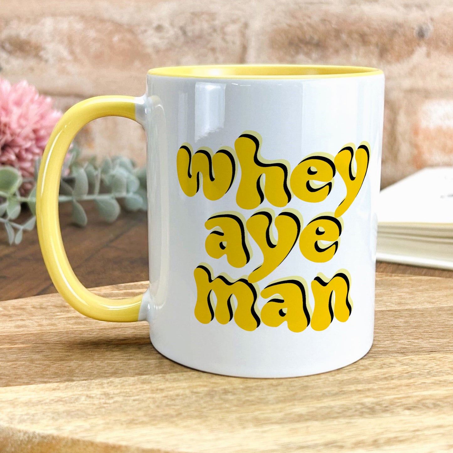 a yellow and white coffee mug sitting on a table