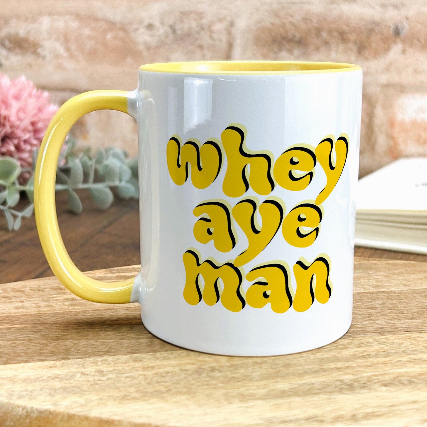a yellow and white coffee mug sitting on a table