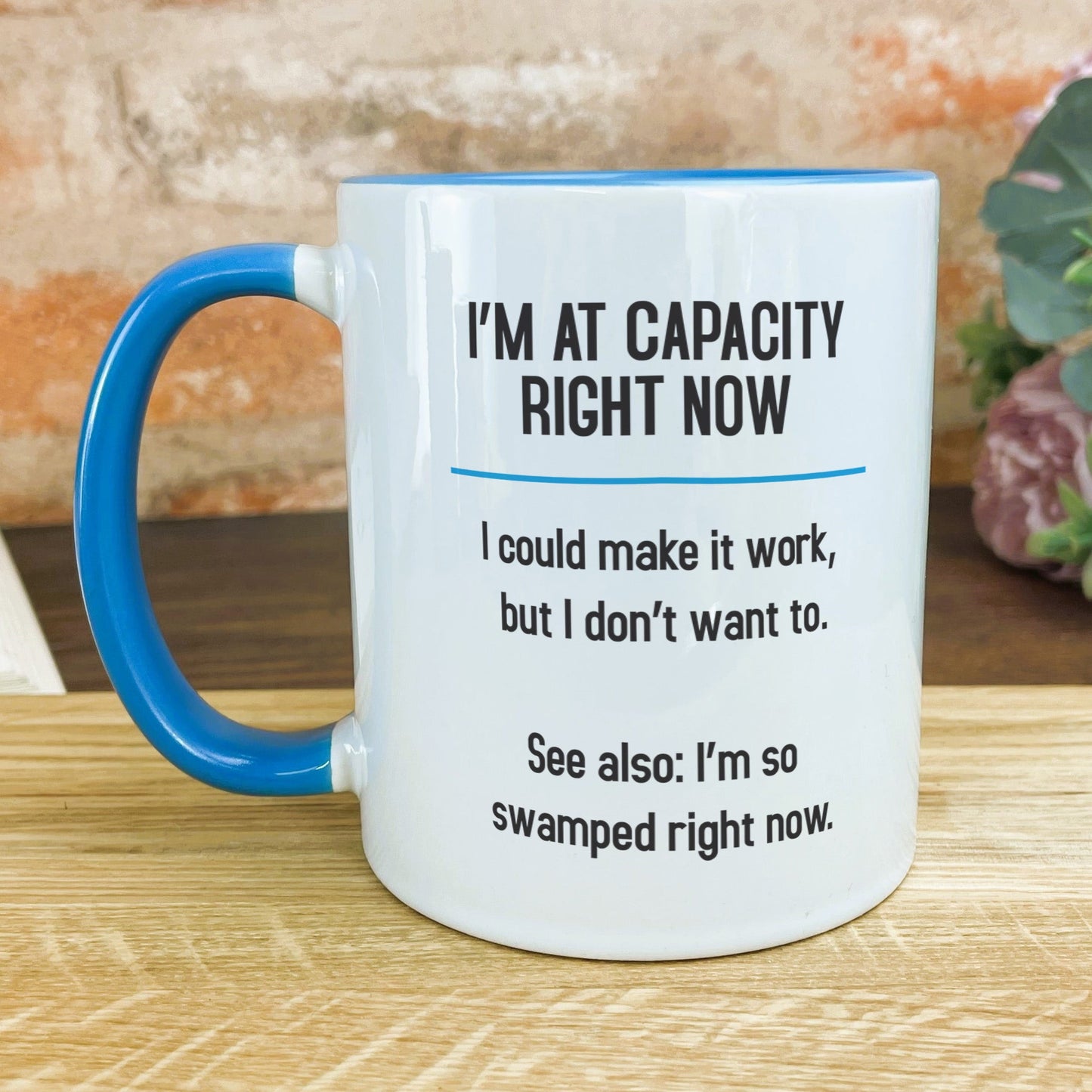 a blue and white coffee mug sitting on top of a wooden table