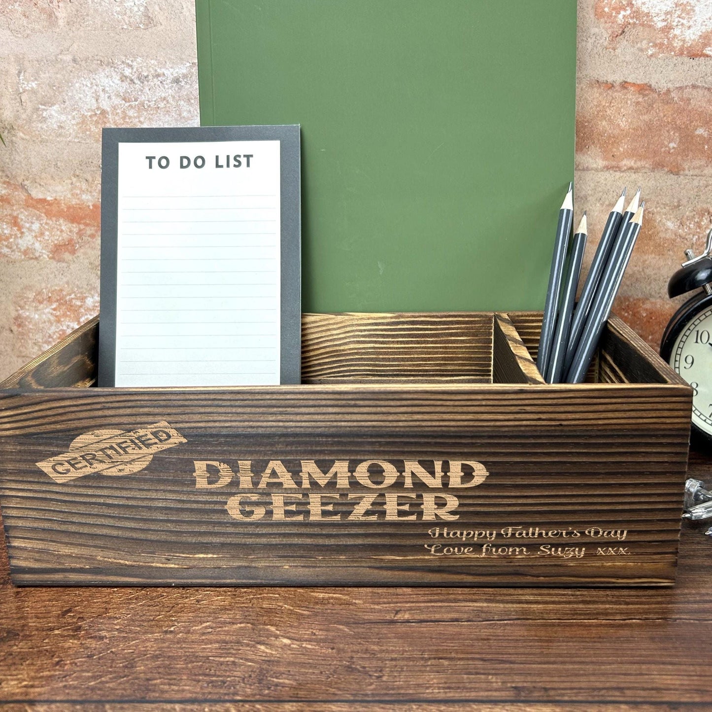 a desk with a clock, notepad and pen holder
