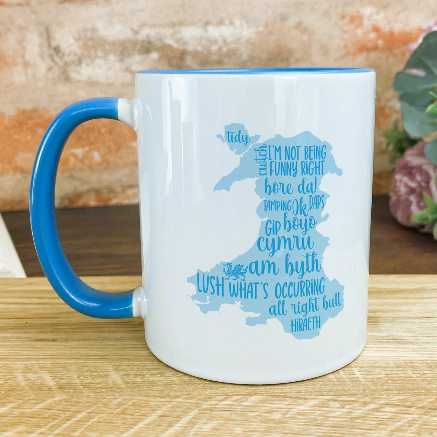 a blue and white mug sitting on top of a wooden table