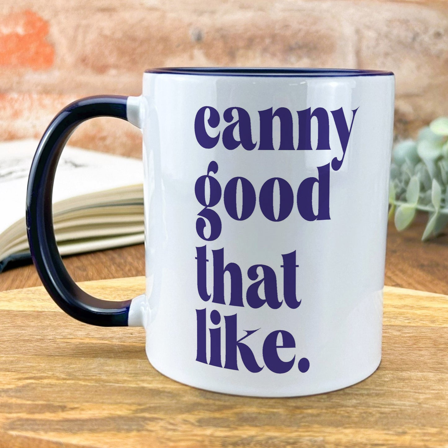 a black and white coffee mug sitting on top of a wooden table