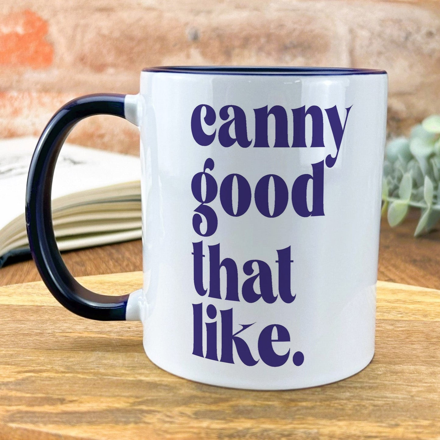 a black and white coffee mug sitting on top of a wooden table