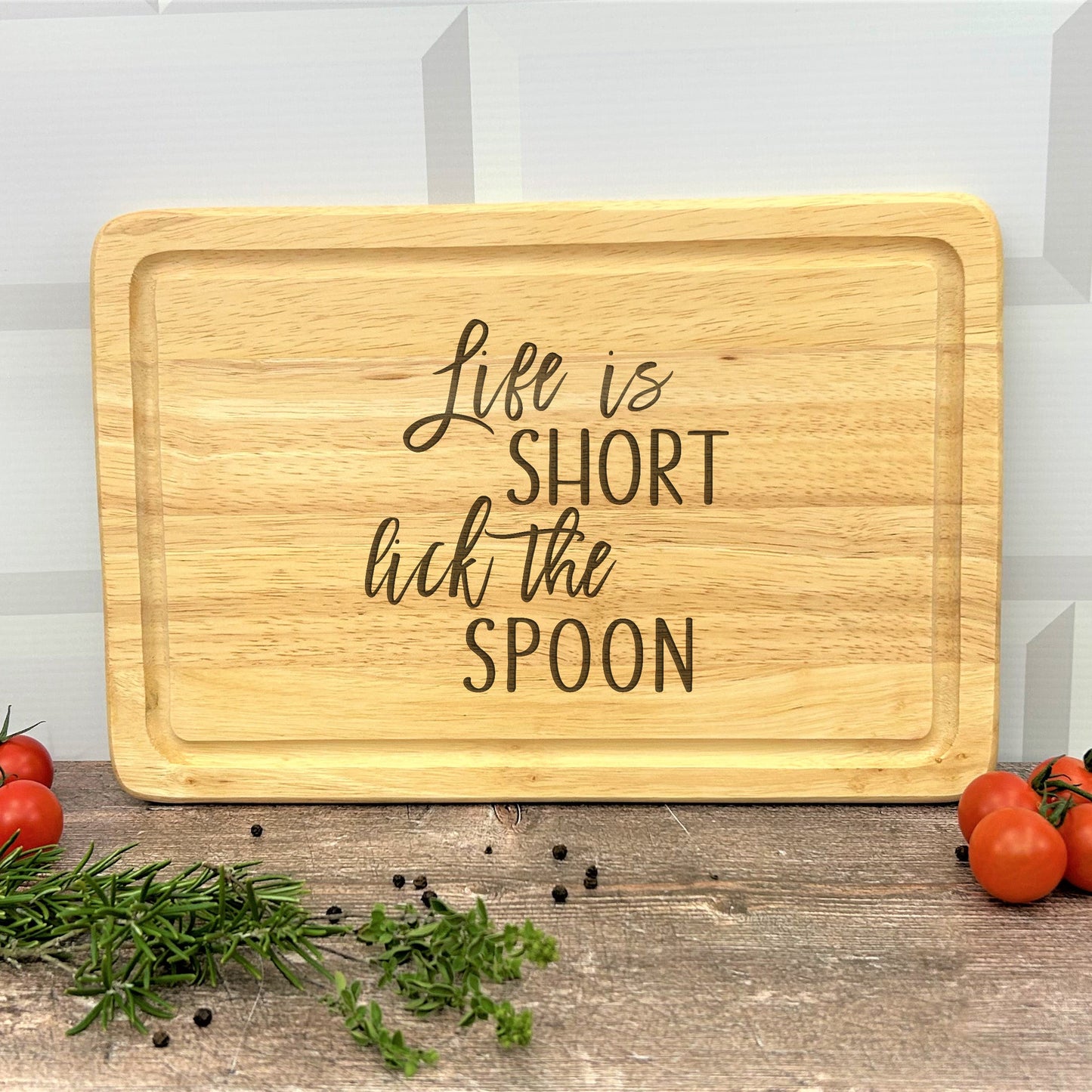 a wooden cutting board that says life is short but the spoon
