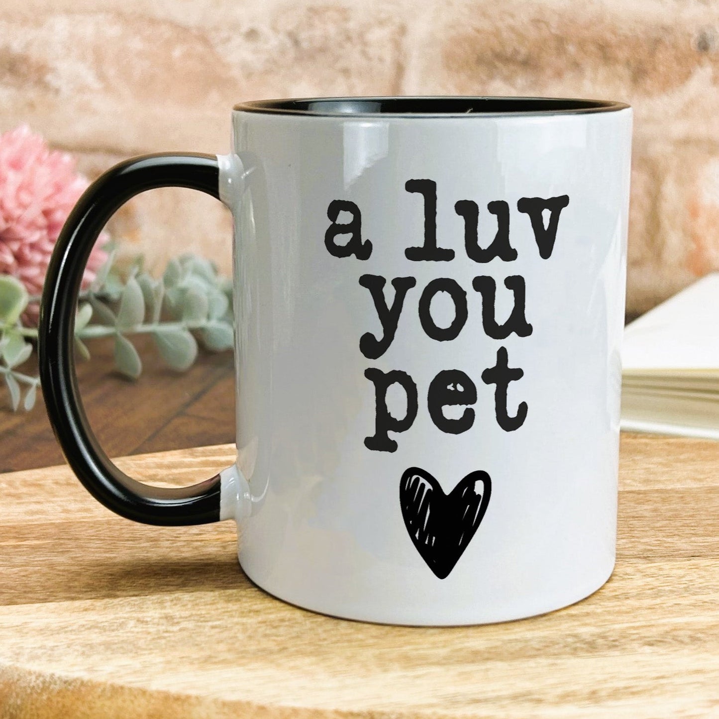 a white and black coffee mug with a black heart on it