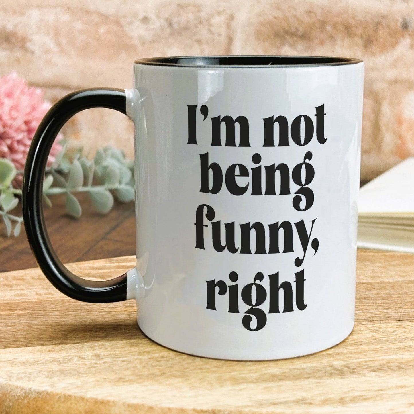 a black and white coffee mug sitting on top of a wooden table