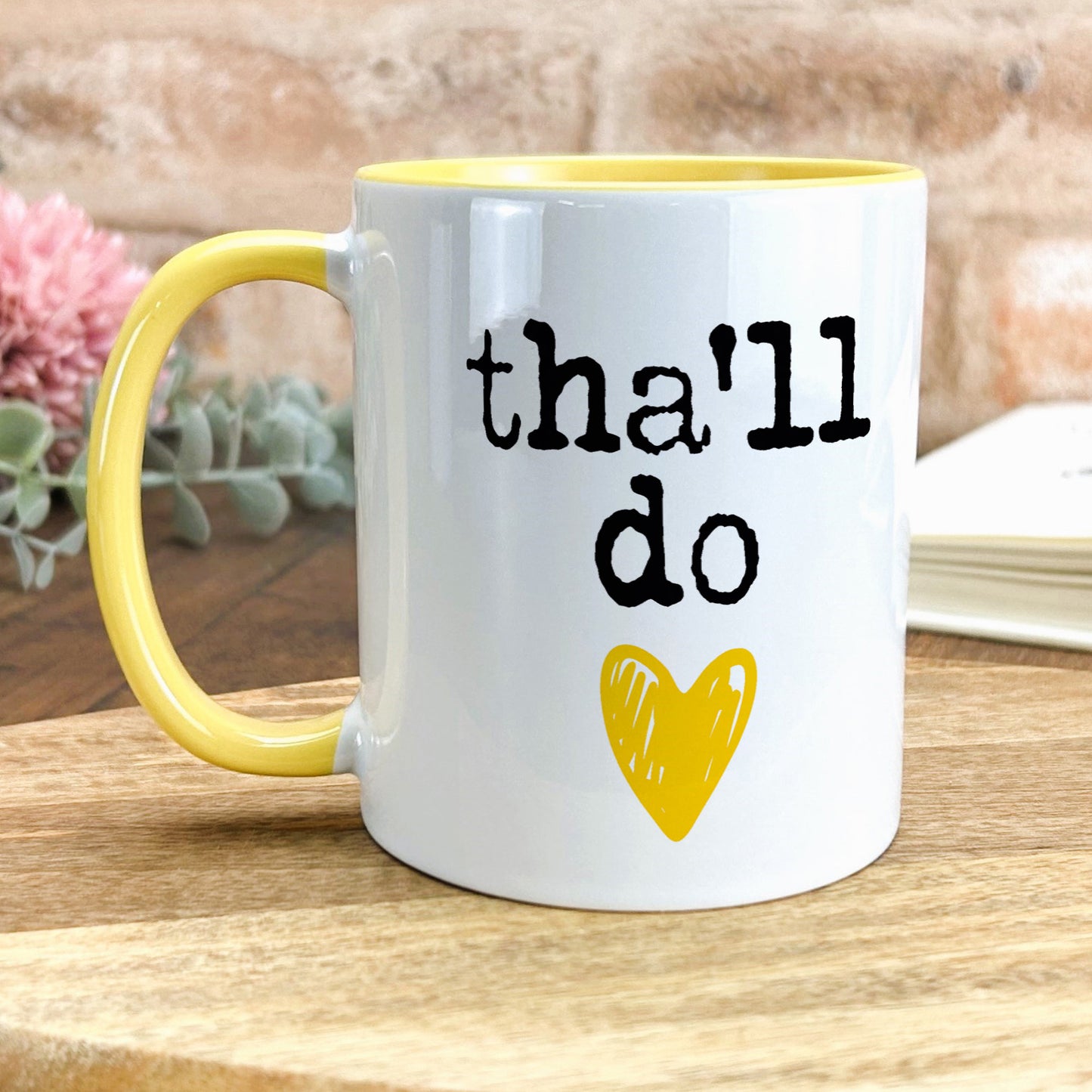 a yellow and white coffee mug with the words that i do on it