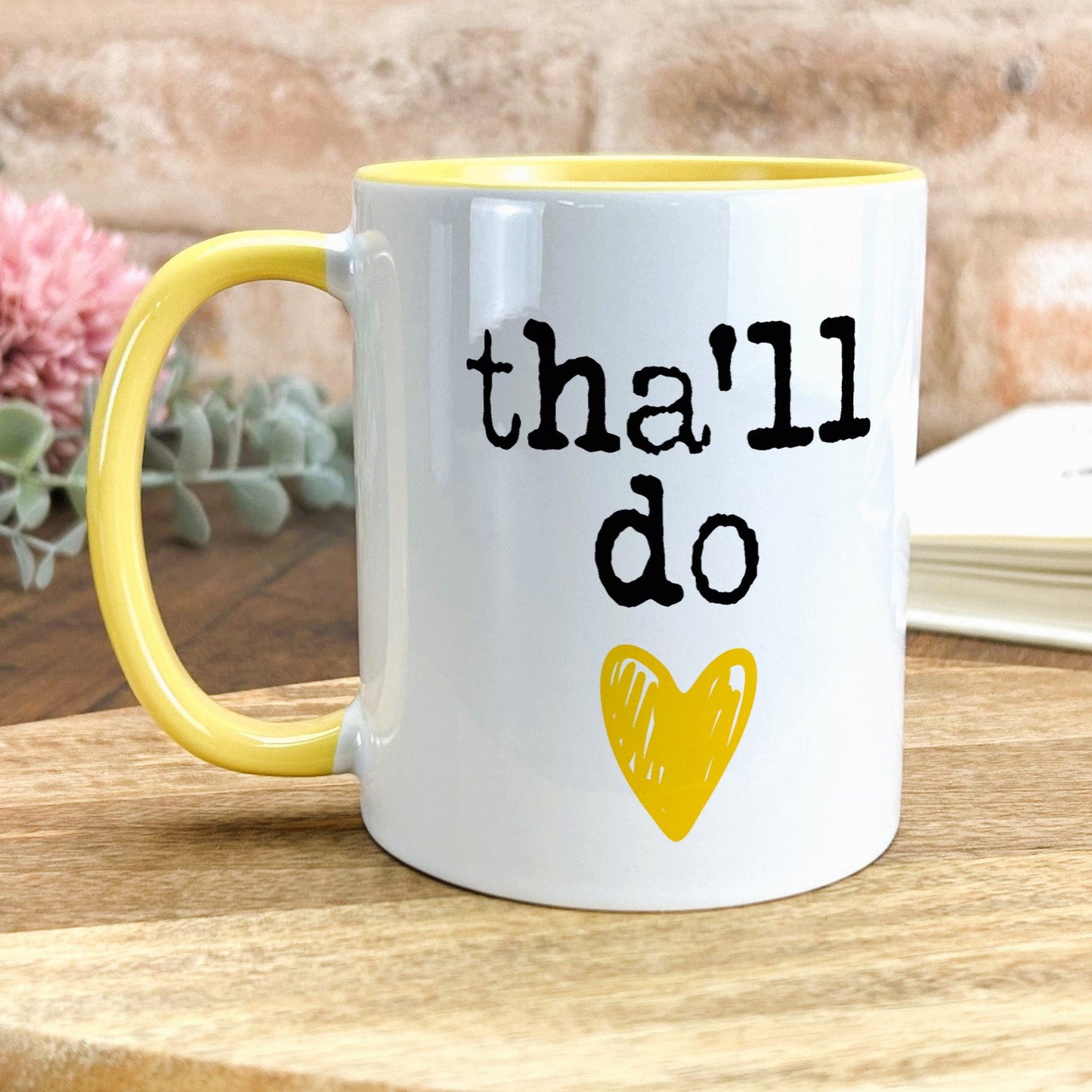 a yellow and white coffee mug with the words that i do on it