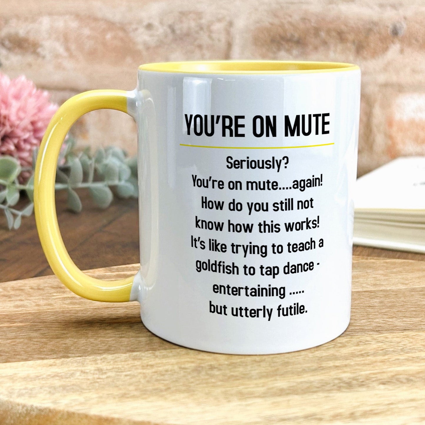 a yellow and white coffee mug sitting on top of a wooden table