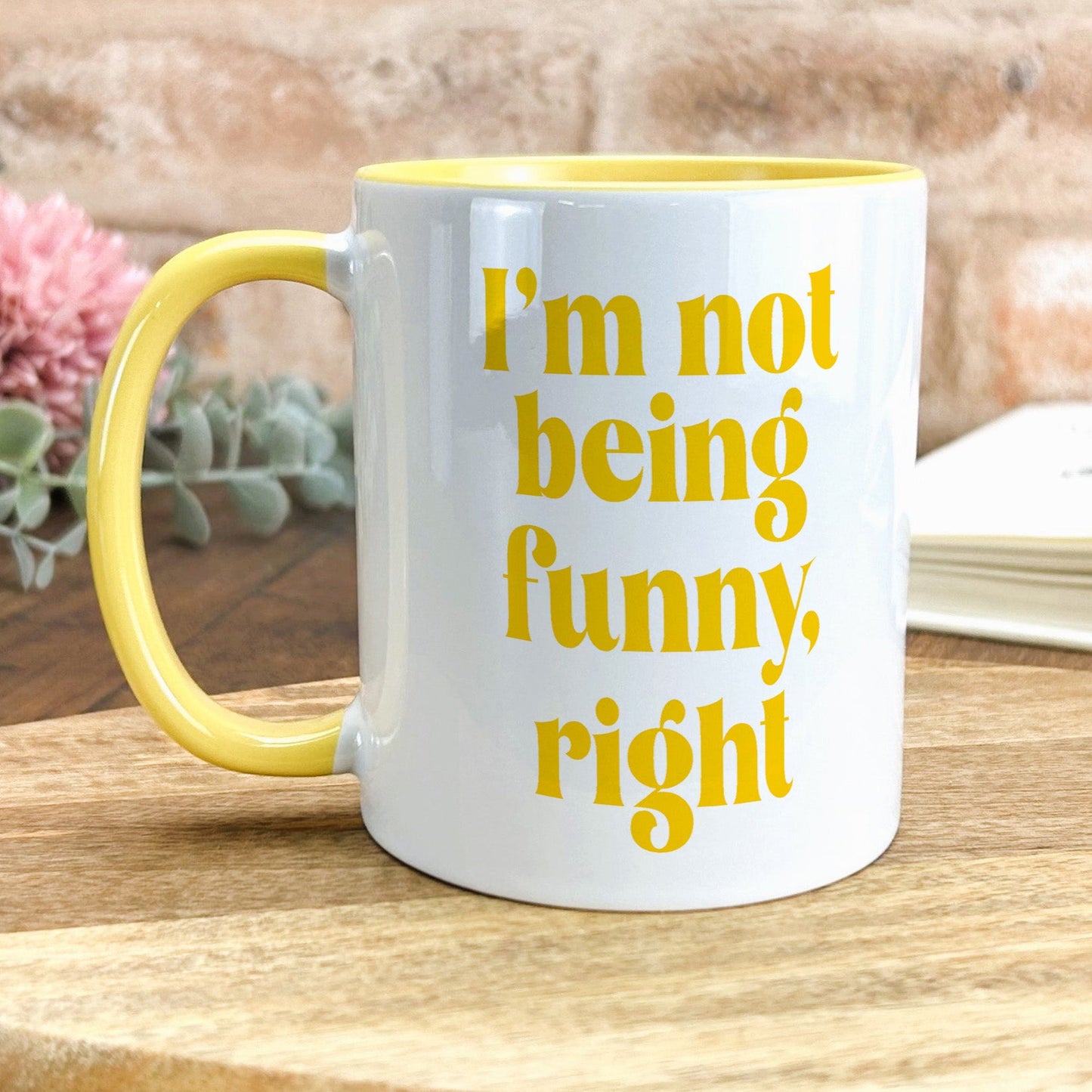 a yellow and white coffee mug sitting on top of a wooden table
