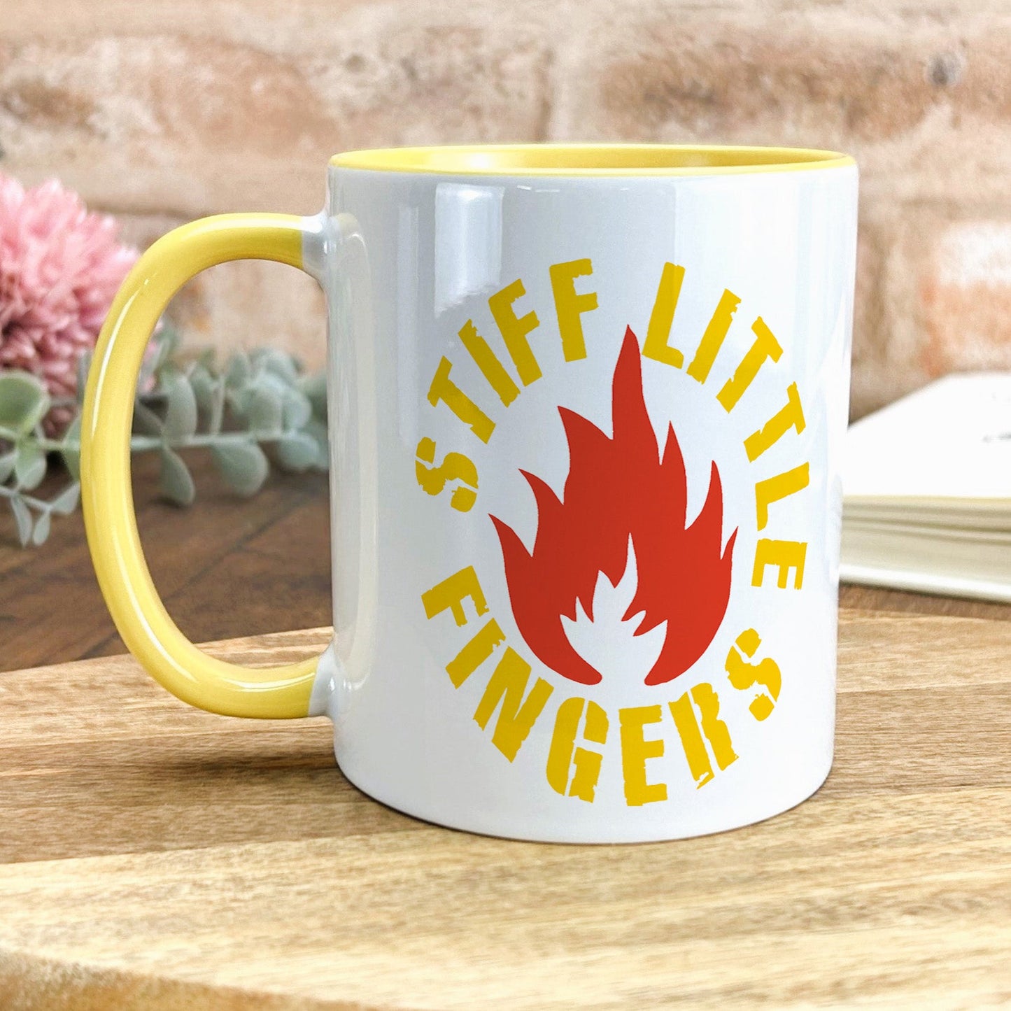 a yellow and white coffee mug sitting on top of a wooden table