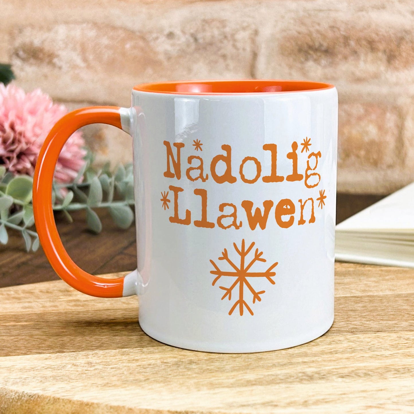 a white and orange coffee mug sitting on top of a wooden table