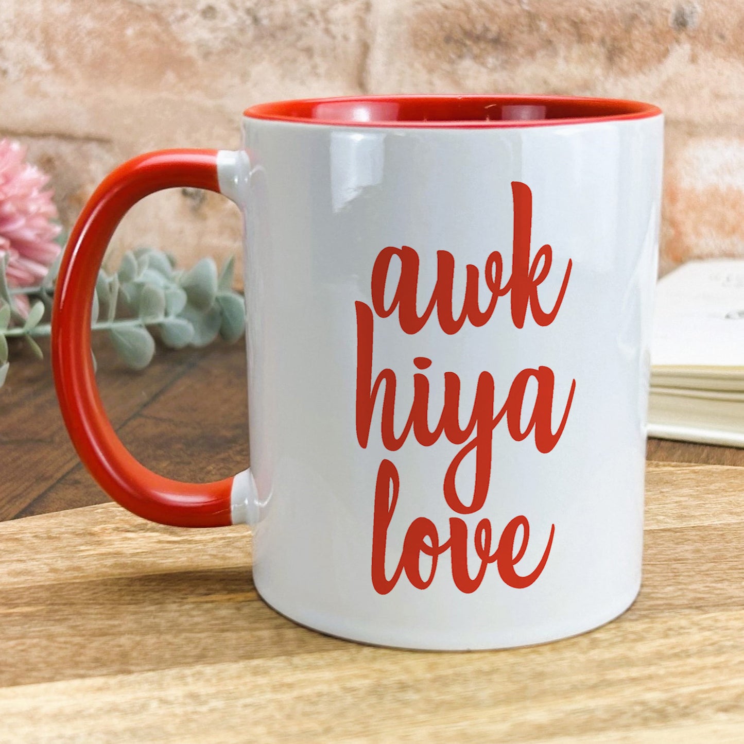 a red and white coffee mug sitting on top of a wooden table