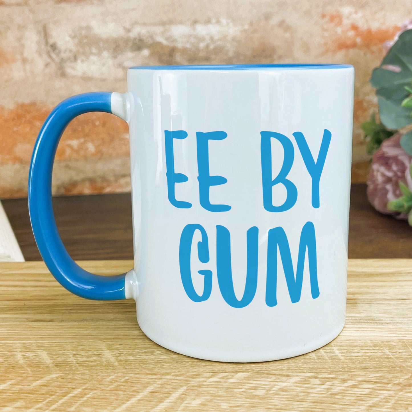 a blue and white coffee mug sitting on top of a wooden table