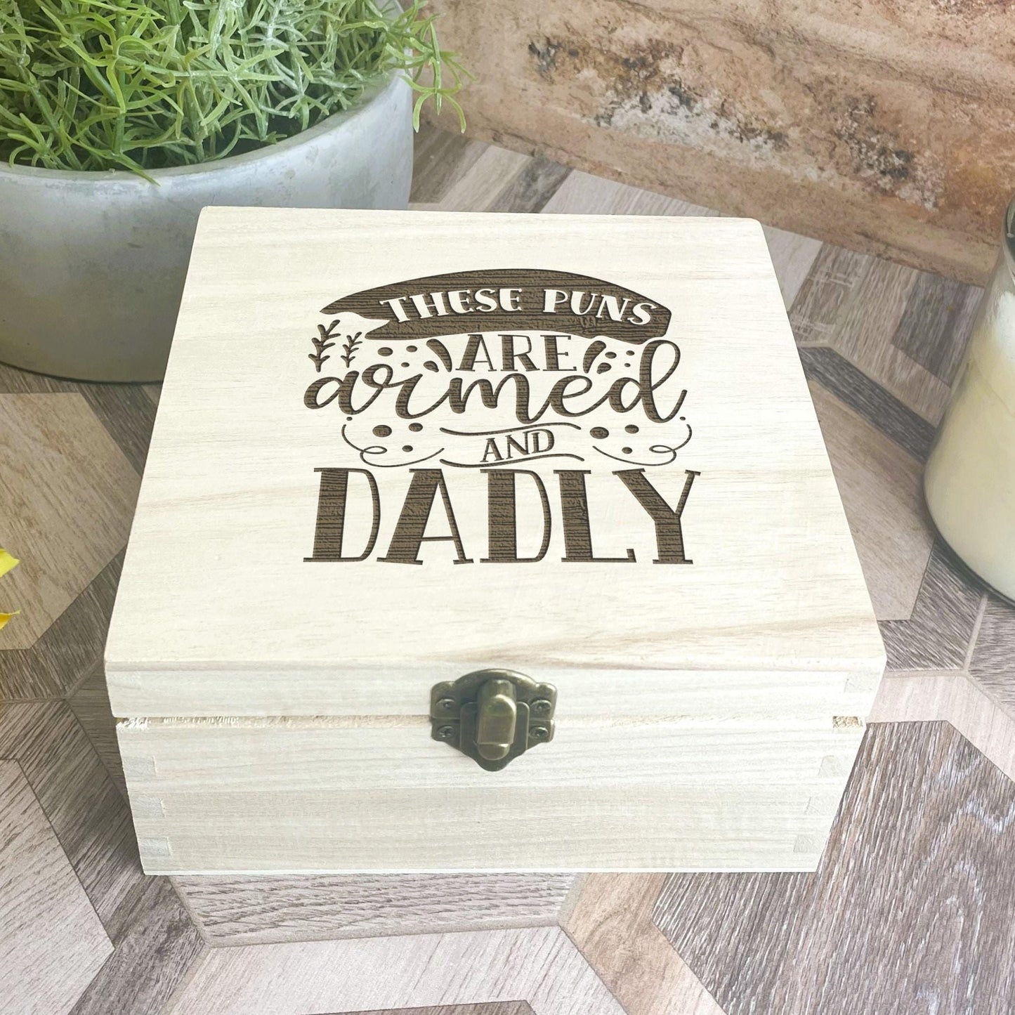 a wooden box sitting on top of a table next to a candle