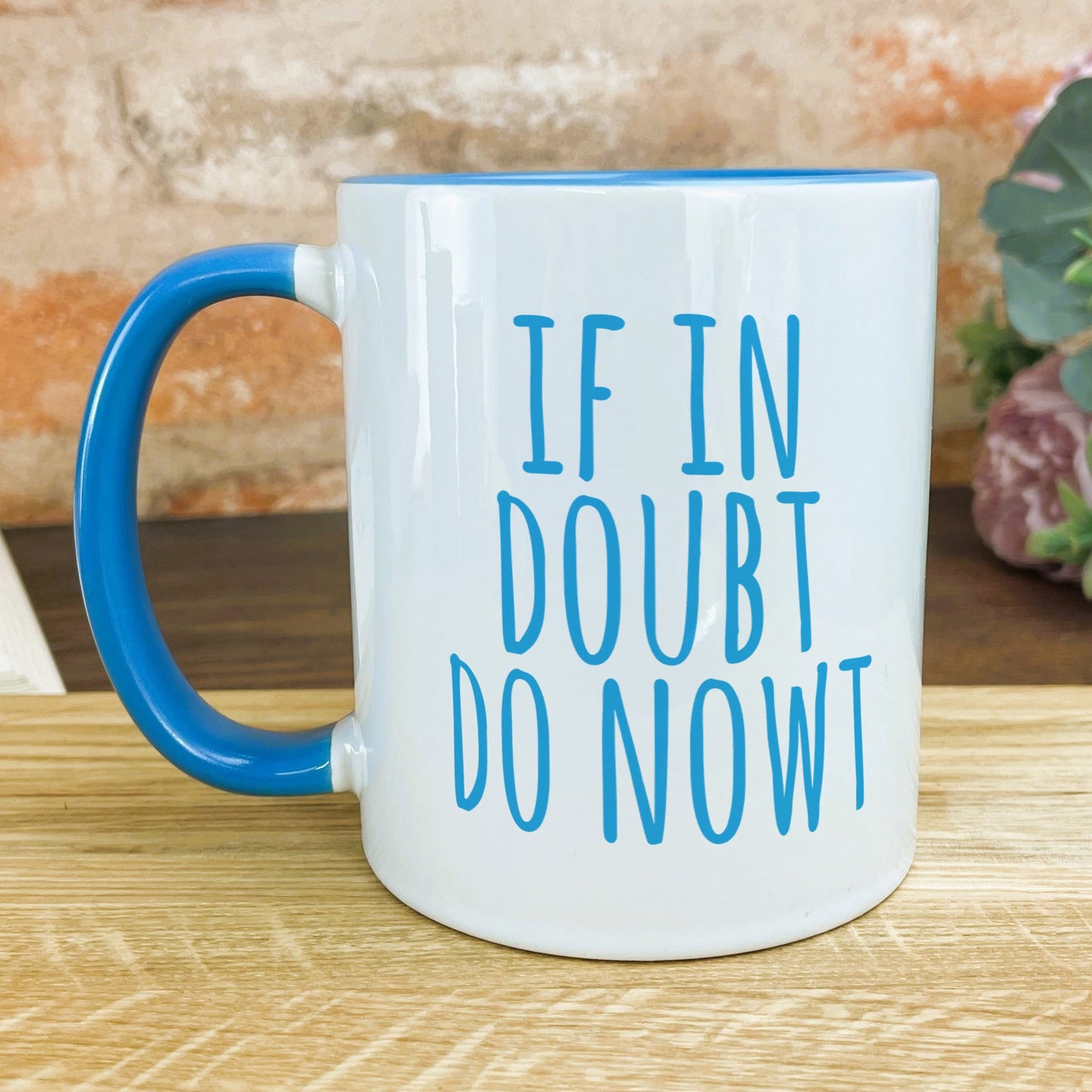 a blue and white coffee mug sitting on top of a wooden table