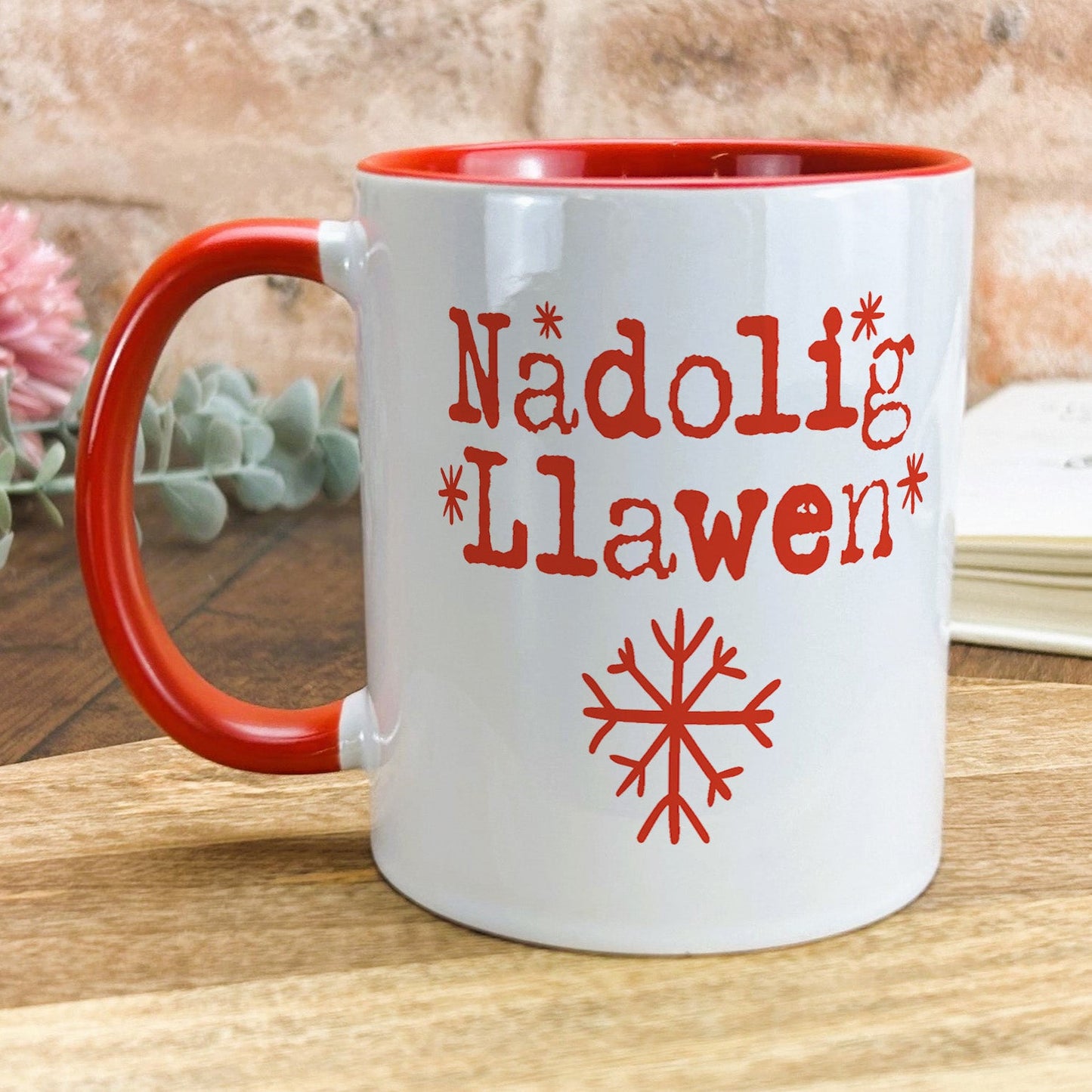 a red and white coffee mug sitting on top of a wooden table