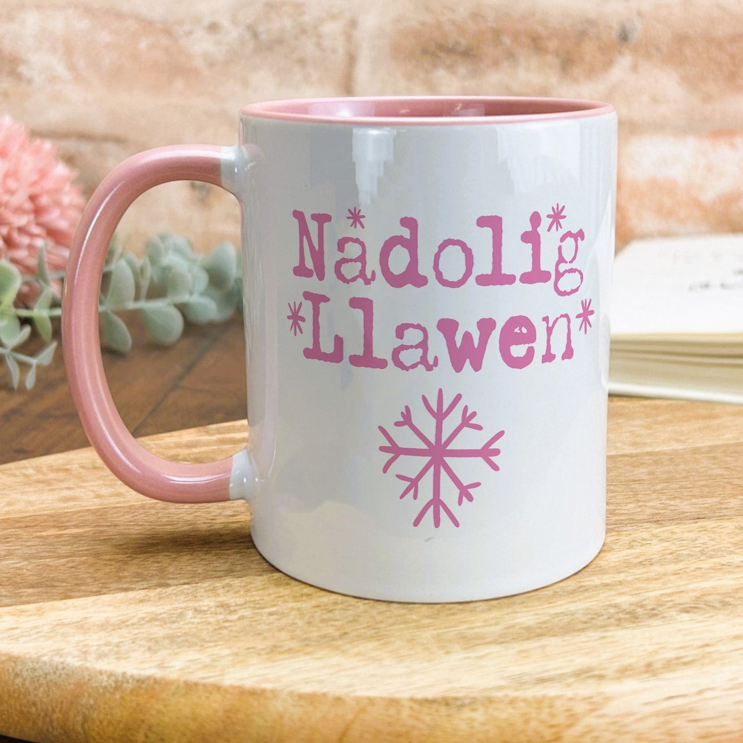 a pink and white mug sitting on top of a wooden table