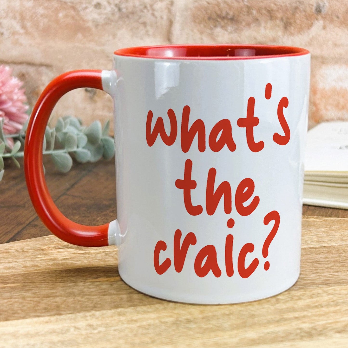 a red and white coffee mug with the words what's the craic