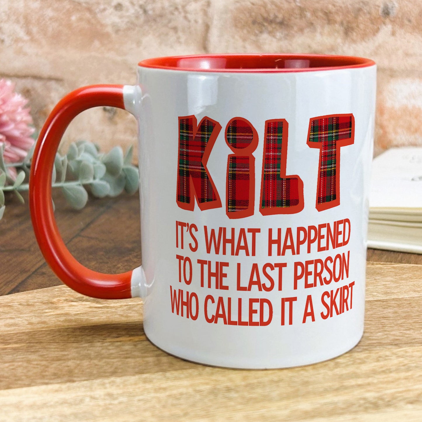 a red and white coffee mug sitting on top of a wooden table