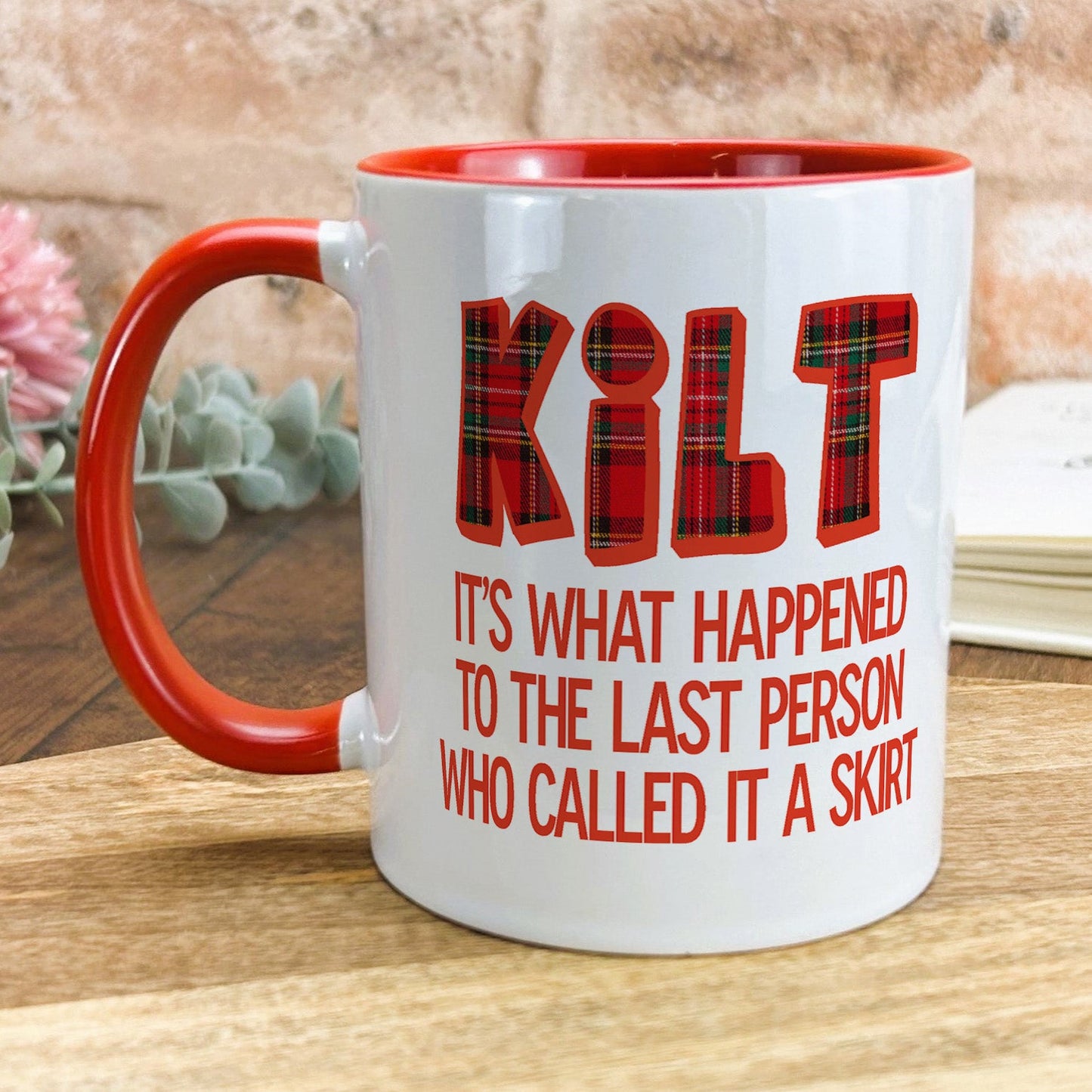 a red and white coffee mug sitting on top of a wooden table
