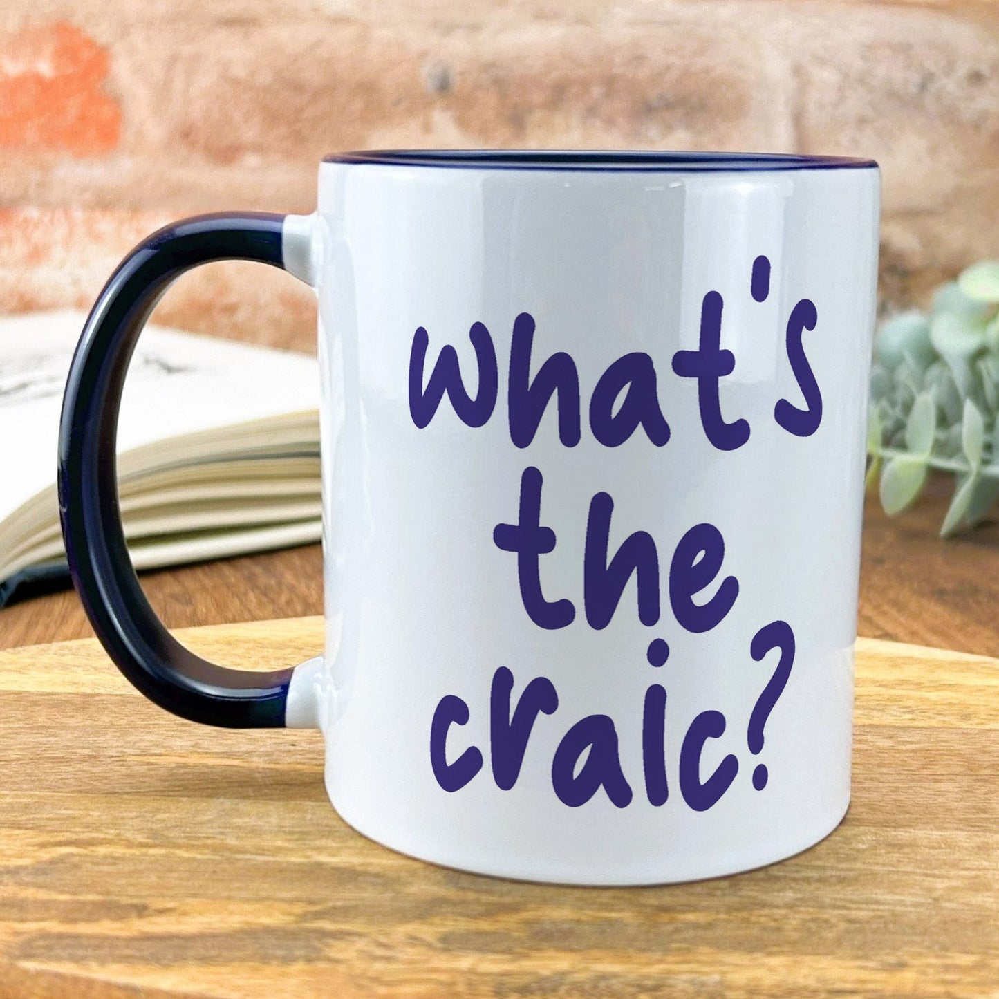 a black and white coffee mug that says what's the craic?