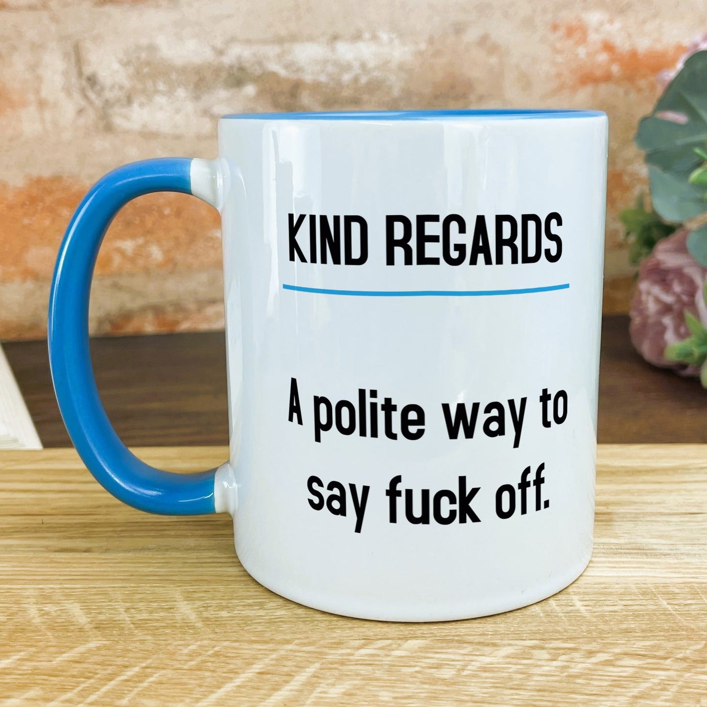 a blue and white coffee mug sitting on top of a wooden table