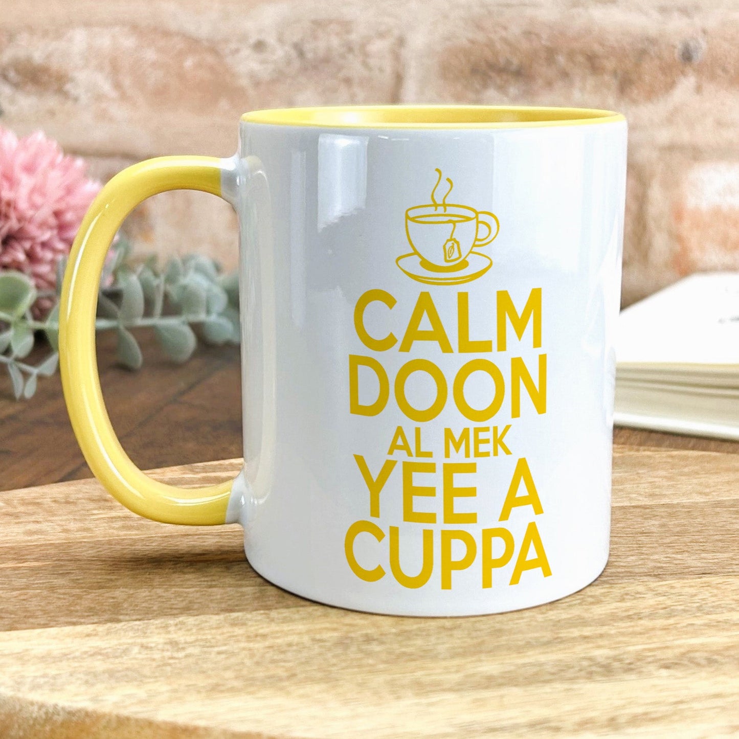 a yellow and white coffee mug sitting on top of a wooden table