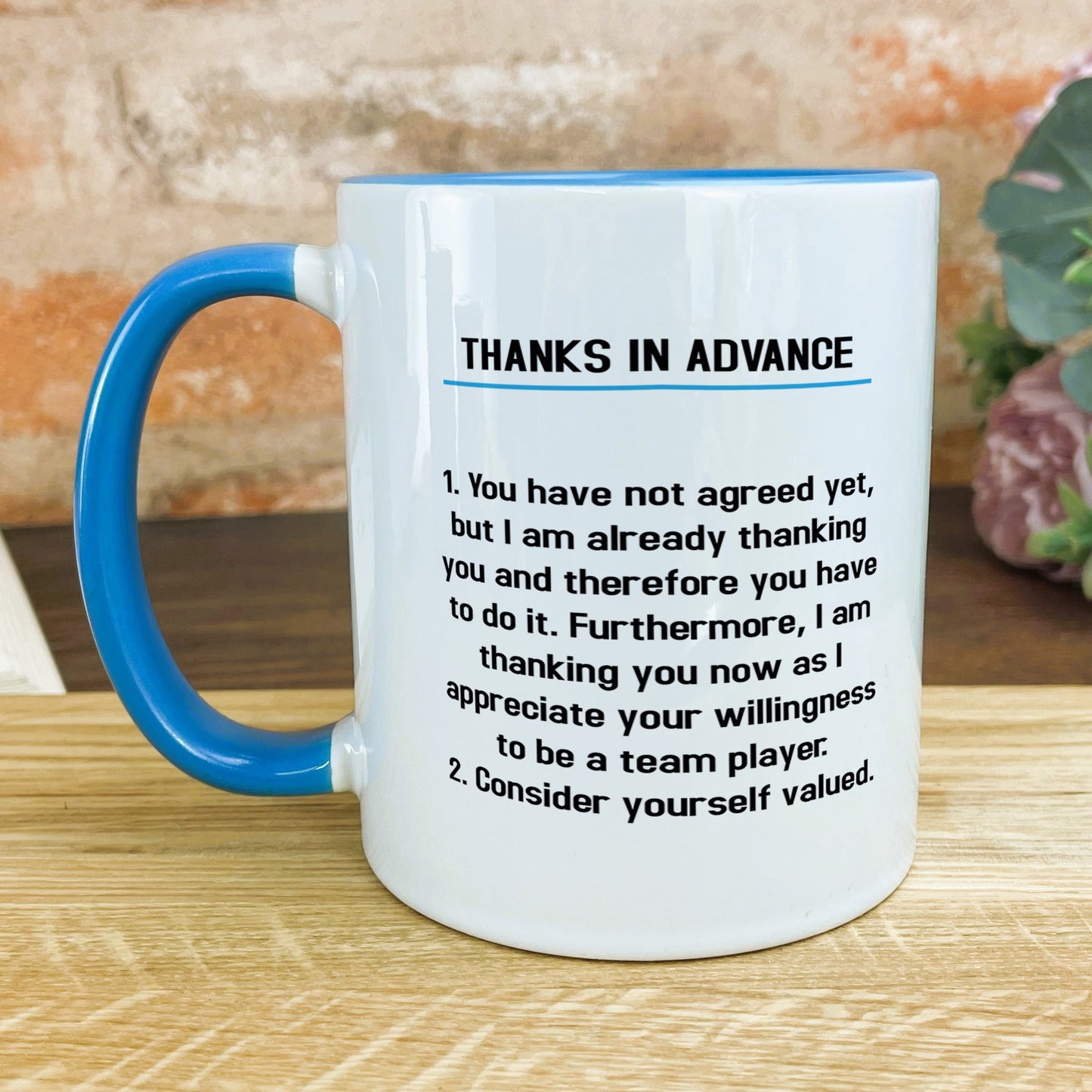 a blue and white coffee mug sitting on top of a wooden table