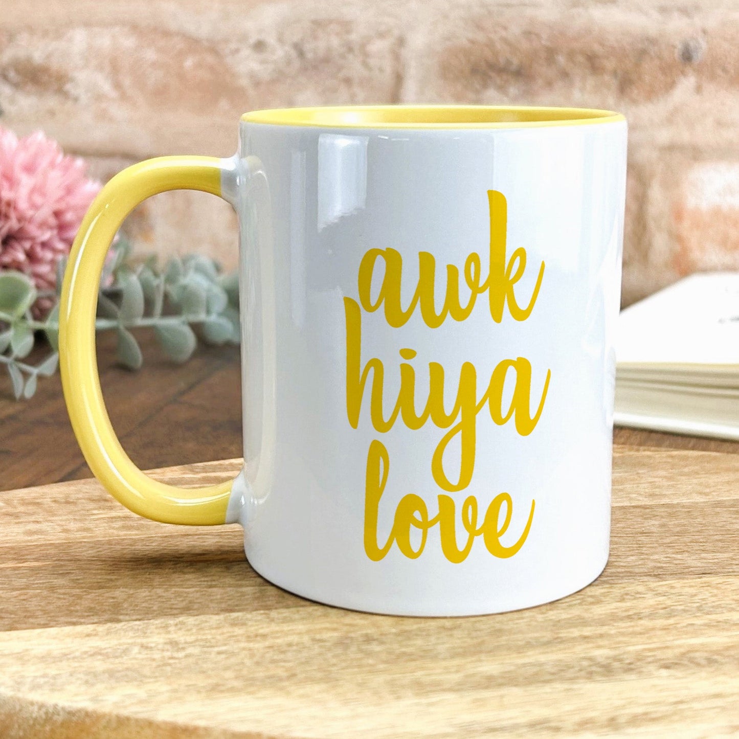 a yellow and white coffee mug sitting on top of a wooden table