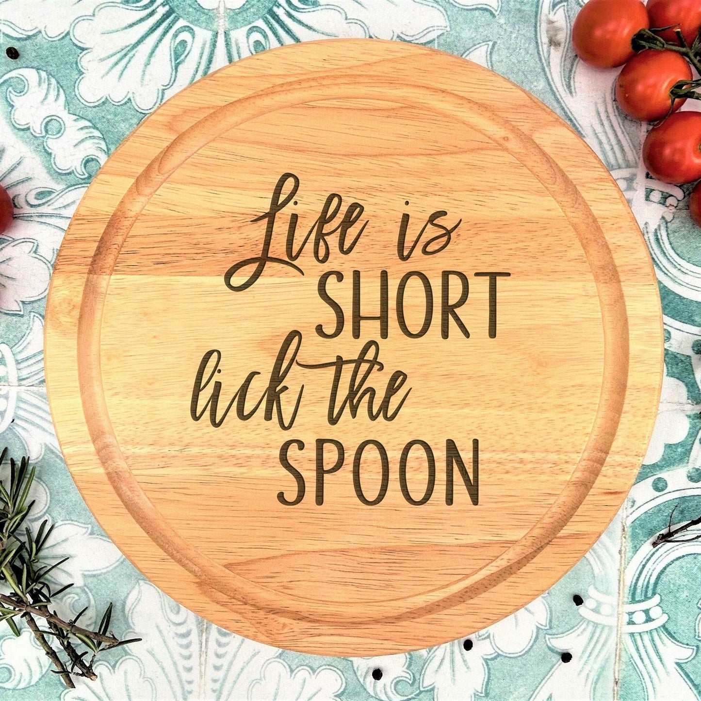 a wooden cutting board that says life is short but the spoon