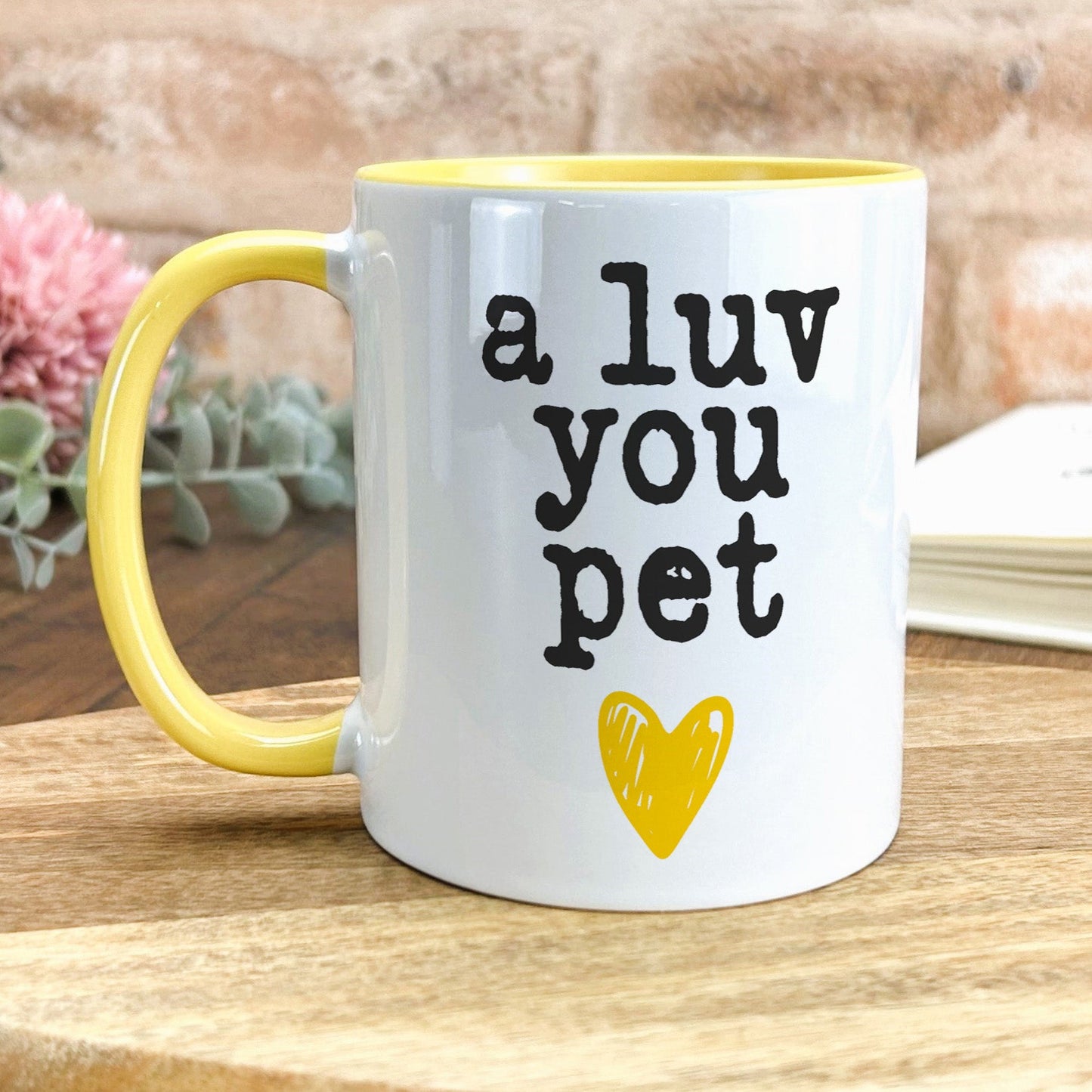 a yellow and white coffee mug that says a luv you pet