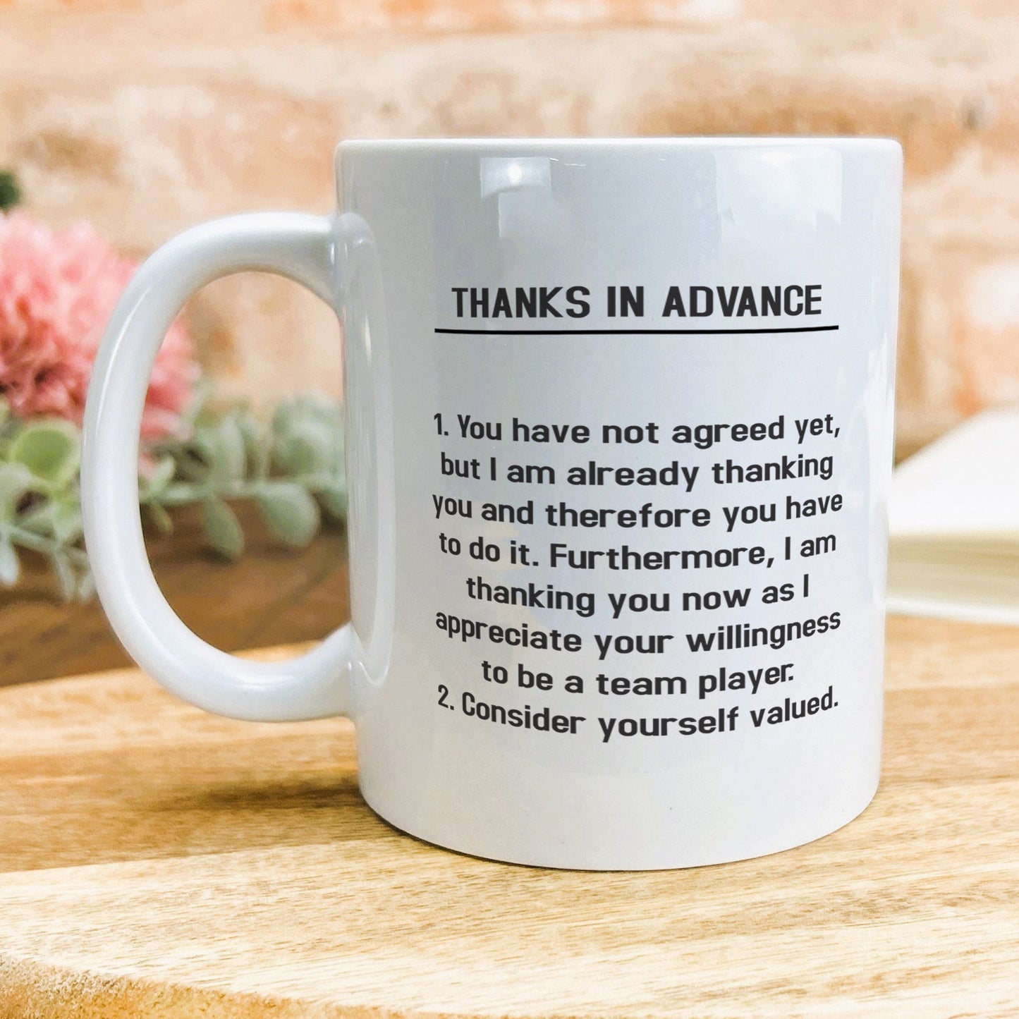 a white coffee mug sitting on top of a wooden table