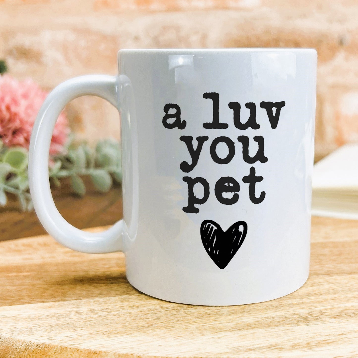 a white coffee mug with the words a luv you pet on it