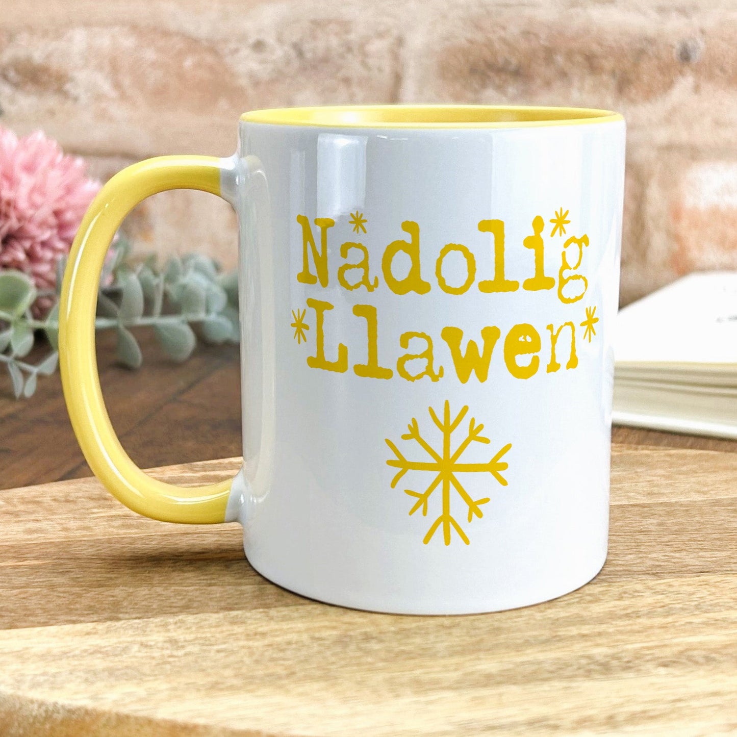 a yellow and white coffee mug sitting on top of a wooden table