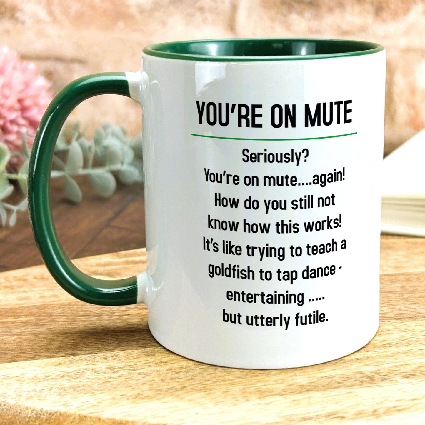 a green and white coffee mug sitting on top of a wooden table