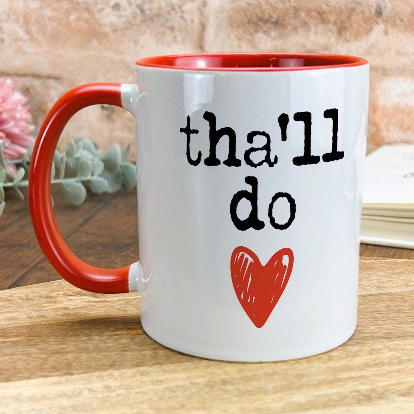 a red and white coffee mug with the words thal do on it