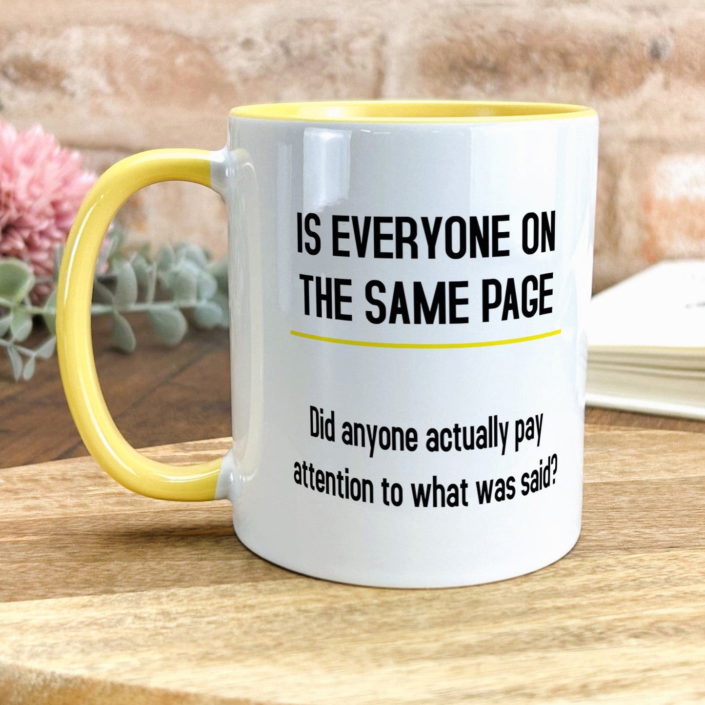 a yellow and white coffee mug sitting on top of a wooden table