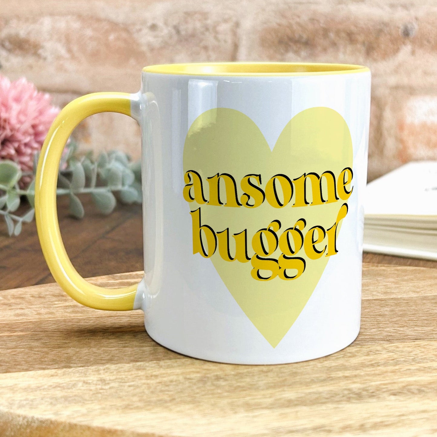 a yellow and white coffee mug sitting on a table