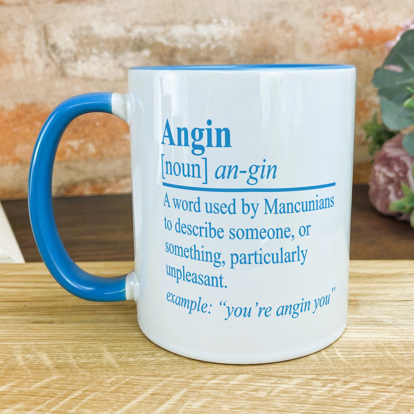 a blue and white coffee mug sitting on top of a wooden table