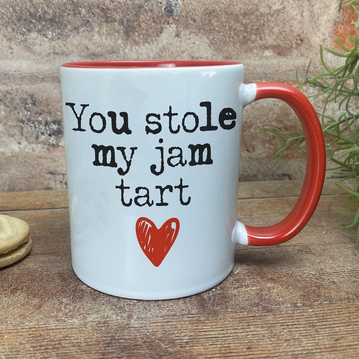 A white mug with a red handle, featuring a humorous text that reads "You stole my jam tart" along with a red heart symbol.