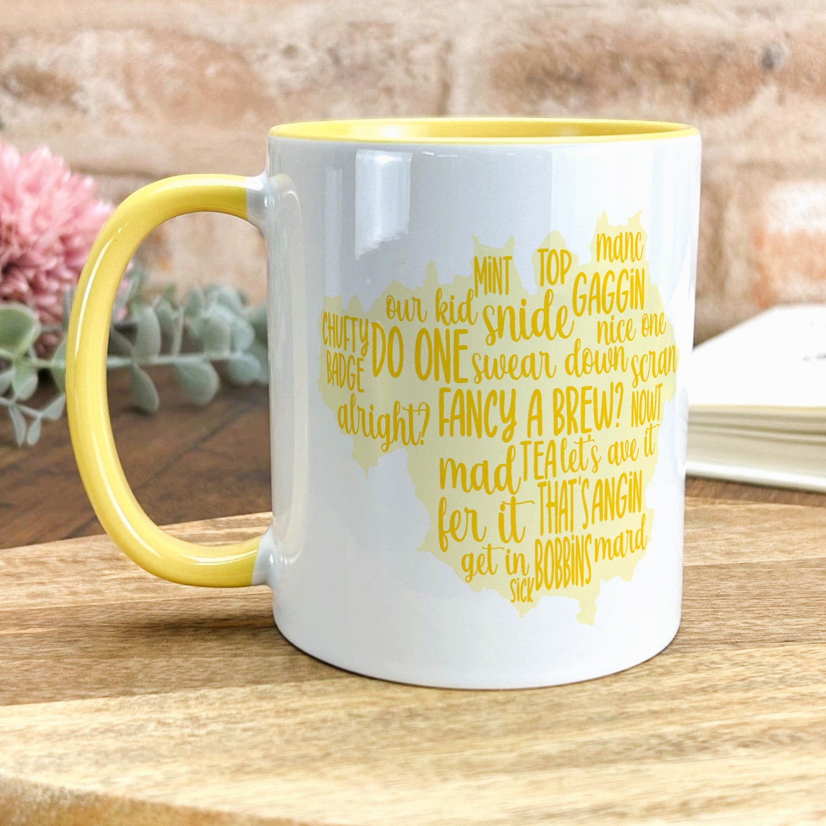 a yellow and white coffee mug sitting on top of a wooden table