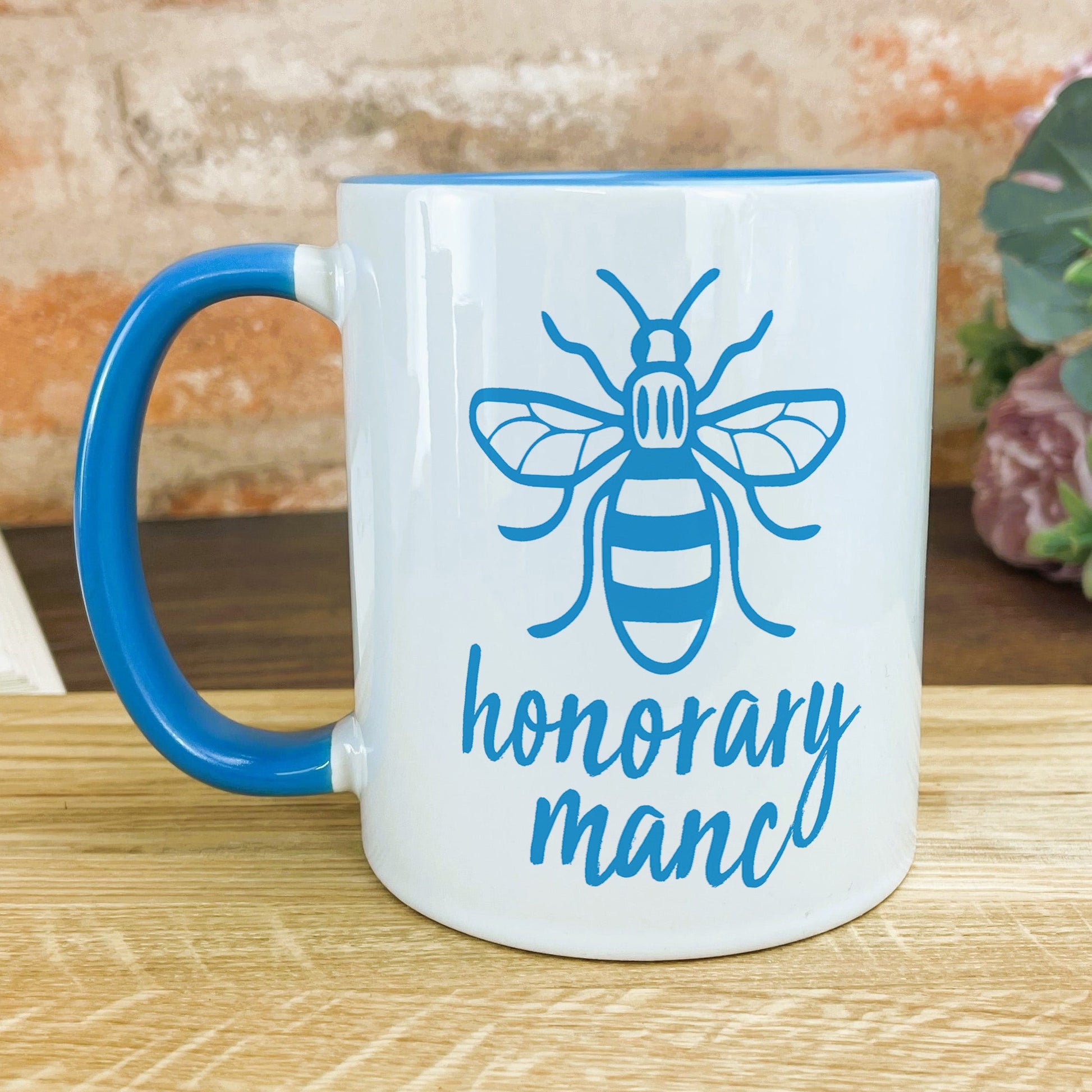 a blue and white coffee mug with a bee on it